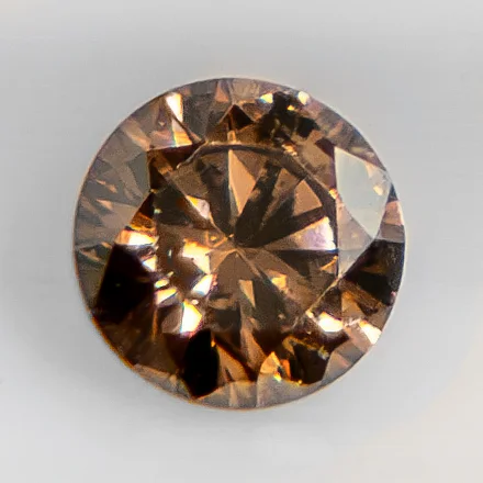 Brown faceted round diamond with visible warm body colour.