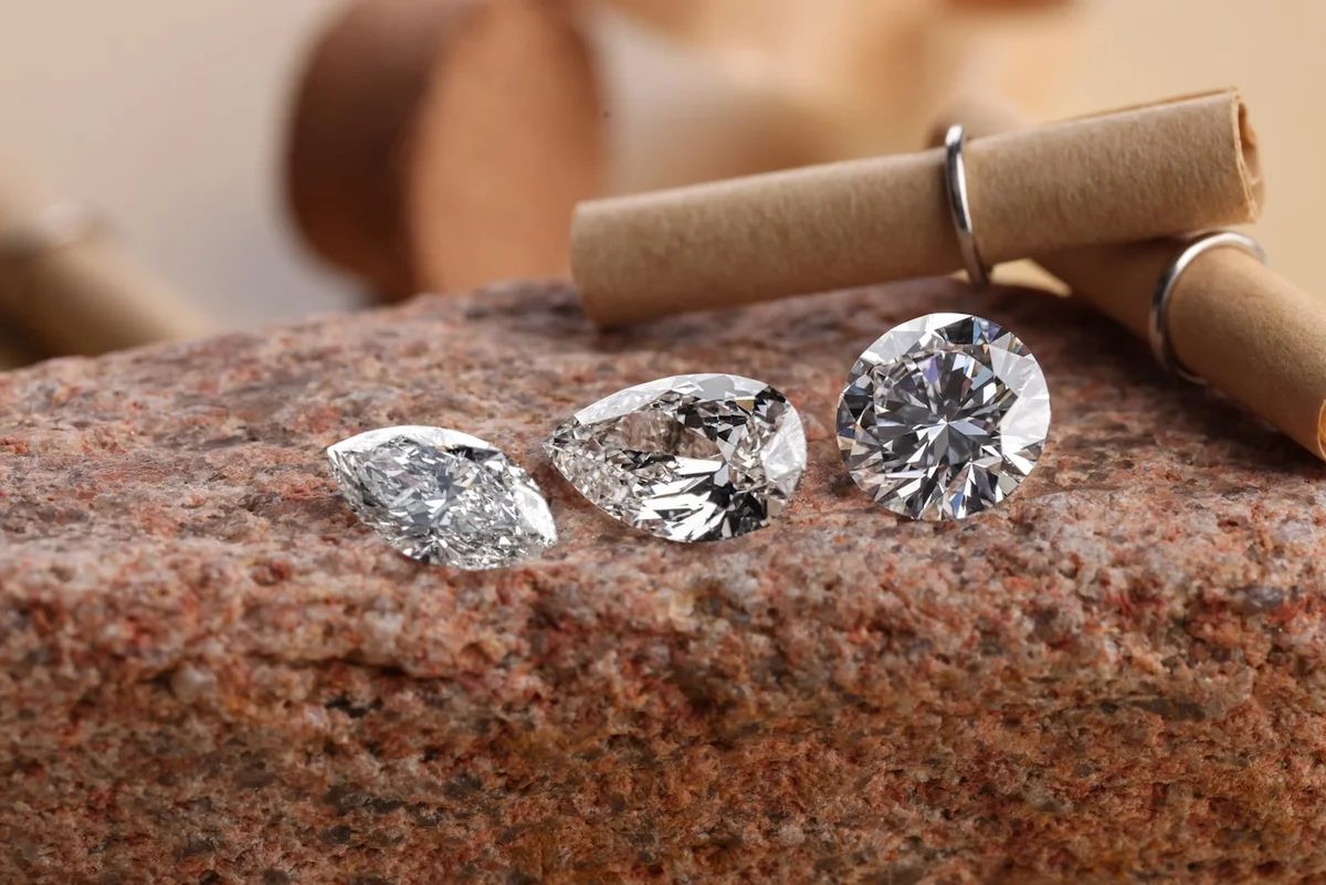 Real marquise, pear and round diamonds standing together on stone.